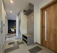 Předsíň v 2-pokojovém bytě s keramickou podlahou a věšákovou stěnou.