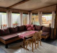 Útulný prostor s dřevěným dekorem, velkou pohovkou a jídelním stolem v 2-pokojovém bytě.