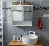 Koupelna v 2-pokojovém bytě s umyvadlem, zrcadlem a věšákem na ručníky.