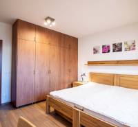 Ložnice s nábytkem ze dřeva a podlahou s dřevěným dekorem v rodinném domě.