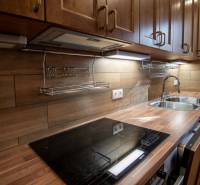 Kuchyně v rodinném domě s podlahou s dřevěným dekorem a kuchyňskou linkou ze dřeva.