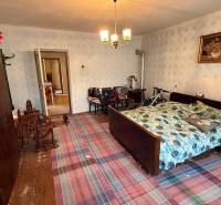 Pokoj v rodinném domě s tradiční postelí, šatní skříní a kolem.