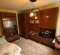 Pokoj v rodinném domě s nábytkem, postelí a vzorovanými tapetami na stěnách.