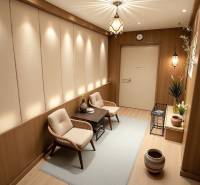 Interiér rodinného domu se světlými květinami, pohodlnými křesly a podlahou s dřevěným dekorem.