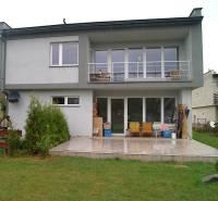 Rodinný dům v Bystričce, terasa s posezením, velká okna a upravený trávník.