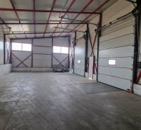 Prostorný prostor s vysokým stropem a velkými branami ve skladech a halách.