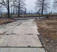 Areál s pevnou cestou a bránou ve Východní ulici v Popradu, sklady a haly.