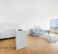 Útulná kuchyně s bílými skříňkami, sedačkou a velkou prosklenou stěnou ve 2pokojovém bytě.