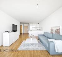 Obývací pokoj s modrou pohovkou, bílým nábytkem a podlahou s dřevěným dekorem ve 2pokojovém bytě.