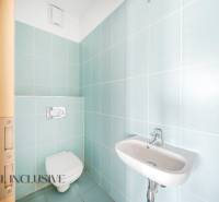 Koupelna s modrými dlaždicemi a závěsným WC v 2-pokojovém bytě.