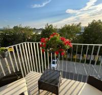 Balkon 3pokojového bytu s výhledem na Odevní ulici v Trenčíně s květinami a zahradním nábytkem.