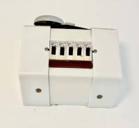 Život v jednopokojovém bytě s bílým plastovým krytem a vypínači.