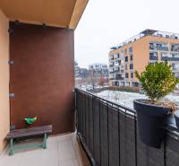 Balkon 1-pokojového bytu na Béžové ulici v Bratislavě - Petržalce se zelení a lavičkou.