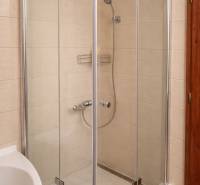 Sprchový kout v 3-pokojovém bytě s jednoduchým designem a světlými obklady.