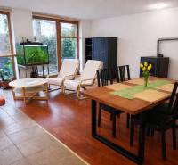 Obývací pokoj ve 3pokojovém bytě s podlahou s dřevěným dekorem, jídelním stolem a akváriem.