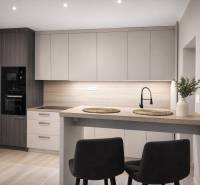 Kuchyně v 2-pokojovém bytě s podlahou s dřevěným dekorem, moderní linkou a jídelním stolem.