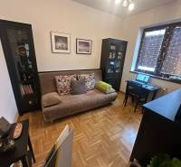 Obývací pokoj s pohovkou a pracovním stolem v rodinném domě s podlahou s dřevěným dekorem.