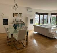 Obývací pokoj v rodinném domě s podlahou s dřevěným dekorem a bílým nábytkem.