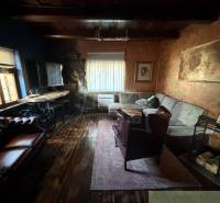 Obývací pokoj v rodinném domě s podlahou s dřevěným dekorem a pohodlným sezením.