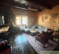 Obývací pokoj v rodinném domě s rustikálním nábytkem a podlahou s dřevěným dekorem.