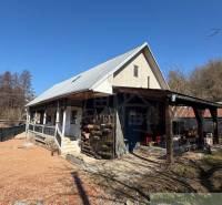 Rodinný dům v Ratkovském Bystrom se sedlovou střechou a dřevěnou verandou.