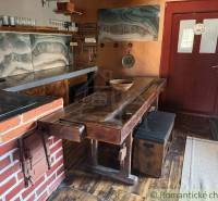 Rustikální kuchyně v rodinném domě s cihlovými detaily a podlahou s dřevěným dekorem.