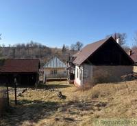 Rodinný dům v Lipovci s kamennou zahradou a přírodním prostředím na svahu.