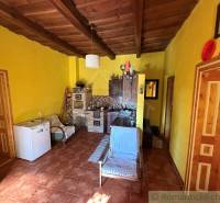 Interiér rodinného domu s dřevěným stropem a žlutými stěnami.