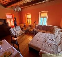 Obývací pokoj v rodinném domě s velkou pohovkou a podlahou s dřevěným dekorem.