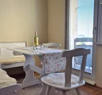 Jídelní kout v 2-pokojovém bytě s podlahou v dřevěném dekoru.