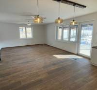 Prostorný obývací prostor s podlahou s dřevěným dekorem v rodinném domě.