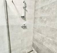 Sprchový kout s moderními obklady a nerezovými doplňky v kanceláři.