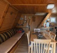 Interiér chaty s dřevěným obložením, schody a podlahou s dřevěným dekorem.