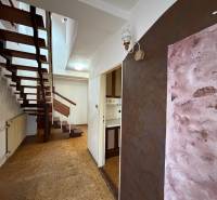 Chodba s otevřenými schody v rodinném domě, podlaha s dřevěným dekorem.