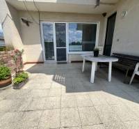 Terasa rodinného domu v Tálové ulici ve Velkém Orvišti s plastovým stolem a květinami.