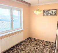 V rodinném domě je pokoj s kobercovou podlahou, závěsným lustrem a malbou.