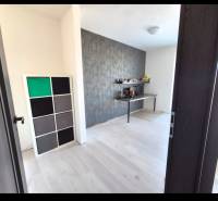 Pokoj v 3-pokojovém bytě s podlahou s dřevěným dekorem a dekorativní stěnou.