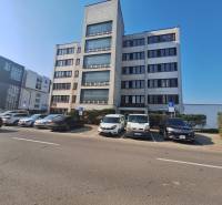 Budova kanceláří na ulici Tulská ve městě Zvolen, s parkovištěm a zaparkovanými auty.