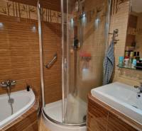 Koupelna v 3-pokojovém bytě s vanou, sprchovým koutem a umyvadlem.