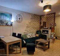 Obývací pokoj s podlahou s dřevěným dekorem a stylovým sezením v 3-pokojovém bytě.