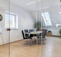 Skleněné stěny, podlaha s dřevěným dekorem a schody v kanceláři.