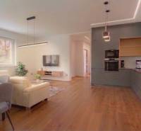 Obývací pokoj v rodinném domě s pohovkou a podlahou s dřevěným dekorem.