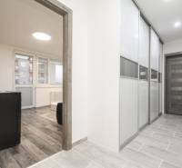 Chodba s posuvnými dveřmi a podlahou s dřevěným dekorem v 3-pokojovém bytě.