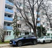 Ulice Pod Párovcami v Piešťanech s bytovým domem a zaparkovanými auty před 2-pokojovým bytem.