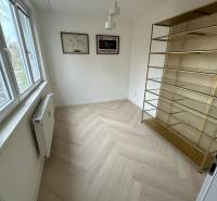 Pokoj v 2-pokojovém bytě s poličkou, podlahou s dřevěným dekorem a oknem.