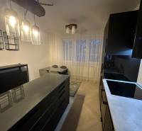 Kuchyně v 2-pokojovém bytě se skleněnými svítidly a podlahou s dřevěným dekorem.