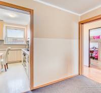 Kuchyně a dětský pokoj ve 4-pokojovém bytě s podlahou s dřevěným dekorem.