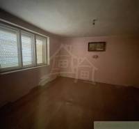 Prázdný pokoj v rodinném domě s podlahou s dřevěným dekorem a velkým oknem.