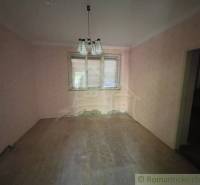 Pokoj v rodinném domě s růžovými stěnami a podlahou s dřevěným dekorem.