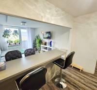 3pokojový byt s barovým pultem a pohodlným posezením, podlaha s dřevěným dekorem.